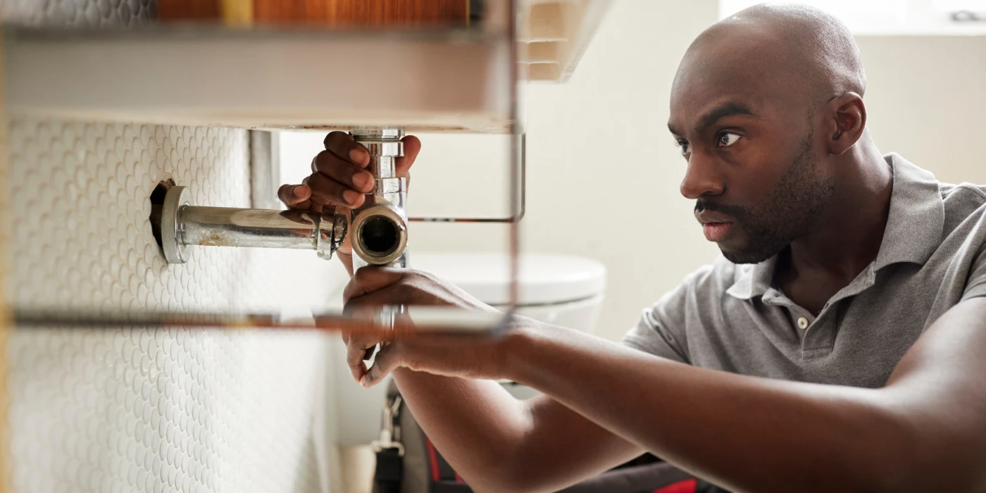 a male plumber fixing a pipe connection from Plumbing Lake Travis in Austin, TX Plumber near me