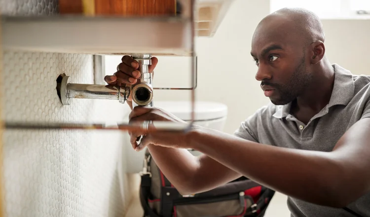 a male plumber fixing a pipe connection from Plumbing Lake Travis in Austin, TX Plumber near me
